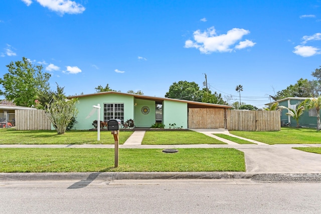 view of front facade featuring stucco siding, fence, and a front yard