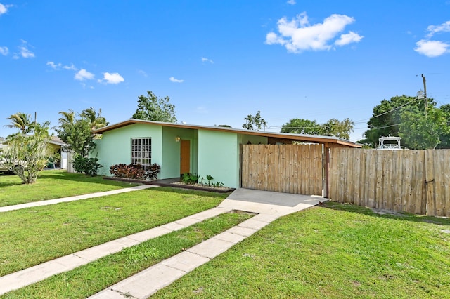 view of front of home with a front yard, fence, and stucco siding