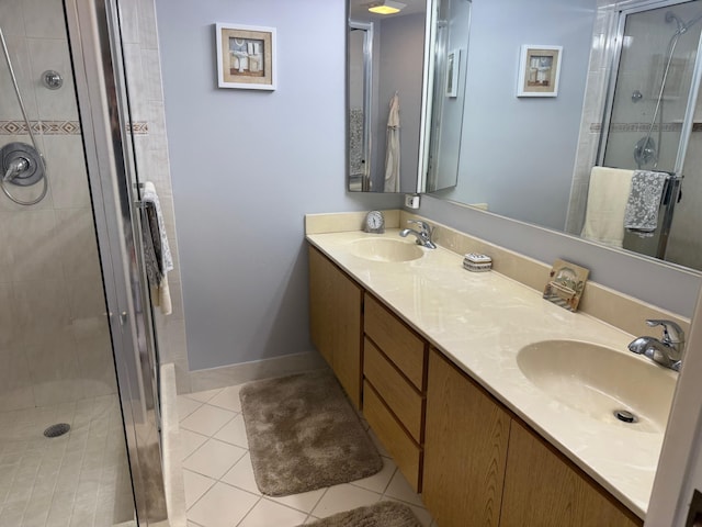 bathroom with double vanity, tile patterned floors, a sink, and a shower stall