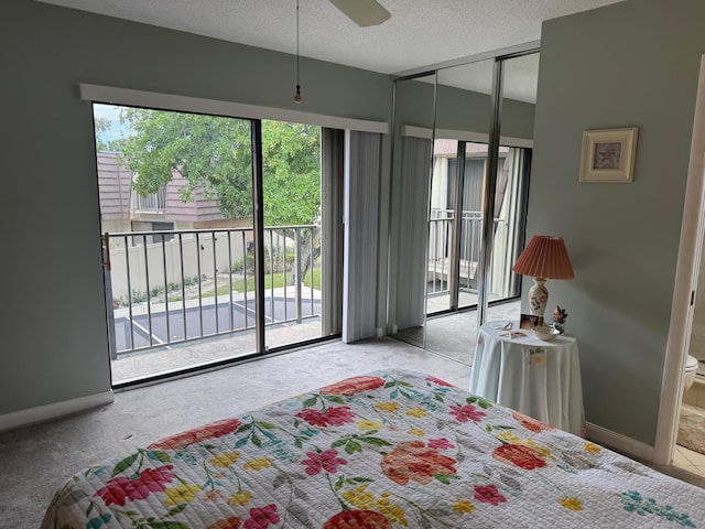 carpeted bedroom featuring access to exterior, a textured ceiling, and baseboards