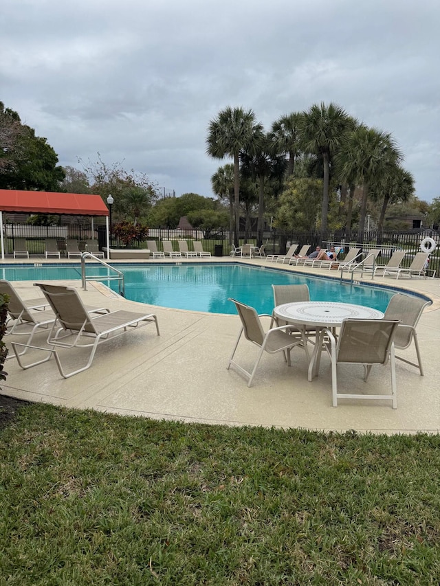 pool featuring fence and a patio