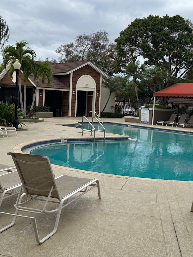 pool featuring fence and a patio