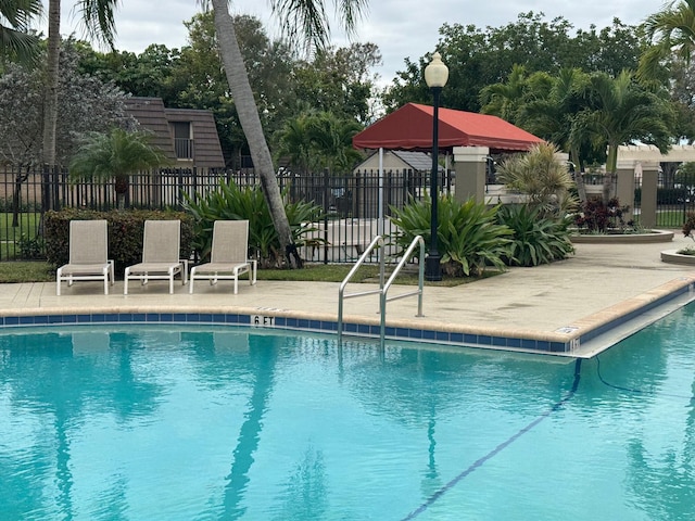 community pool featuring a patio area and fence