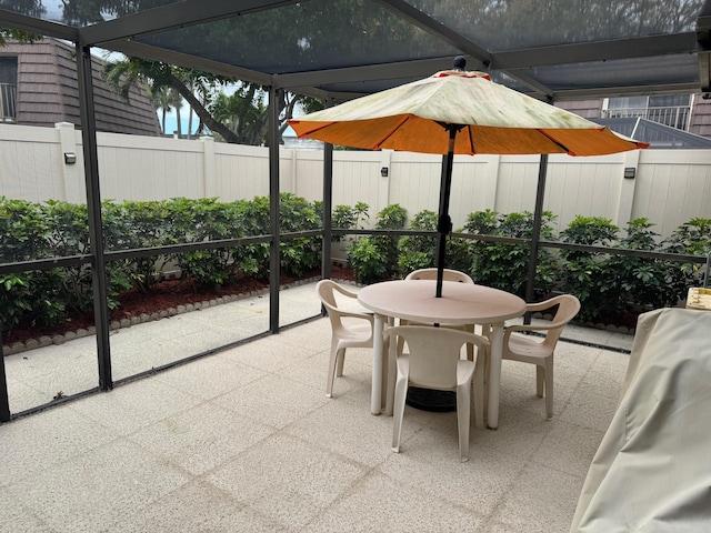 view of patio featuring a lanai, a fenced backyard, and outdoor dining space