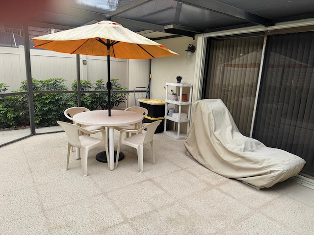 view of patio featuring outdoor dining area and fence