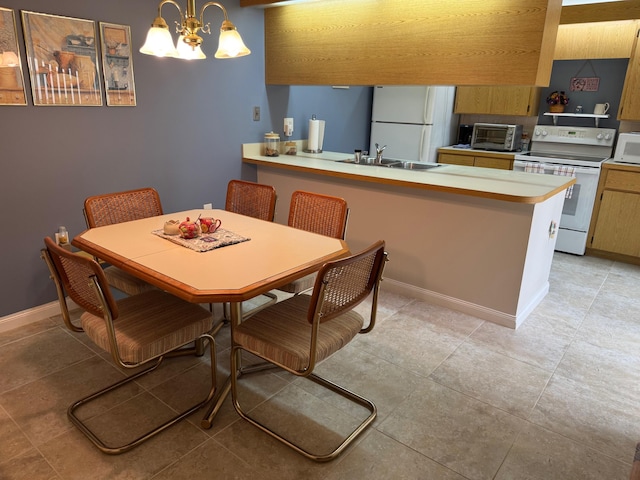 dining space featuring an inviting chandelier, a toaster, light tile patterned floors, and baseboards