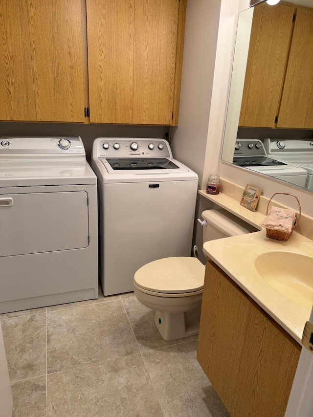 washroom with laundry area, a sink, and washing machine and clothes dryer