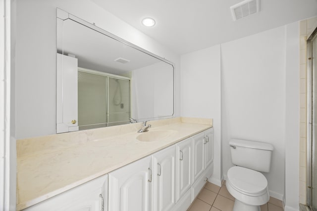 bathroom featuring a stall shower, visible vents, toilet, tile patterned floors, and vanity