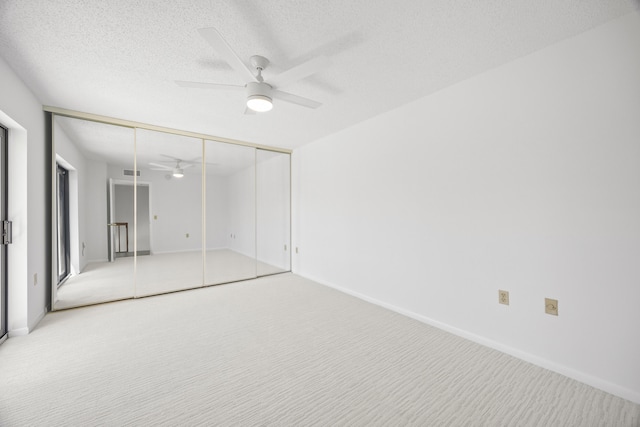 unfurnished bedroom featuring visible vents, ceiling fan, a textured ceiling, carpet floors, and a closet