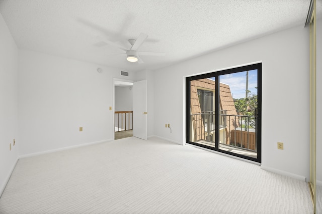 unfurnished room featuring visible vents, light colored carpet, a textured ceiling, and baseboards