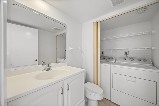 bathroom featuring toilet, separate washer and dryer, vanity, and visible vents