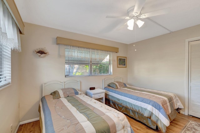 bedroom with ceiling fan, wood finished floors, and baseboards