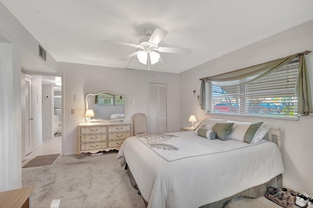 bedroom with light carpet, ceiling fan, a closet, and visible vents