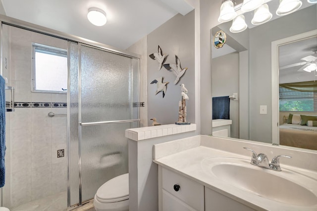 bathroom with a stall shower, a ceiling fan, toilet, ensuite bathroom, and vanity