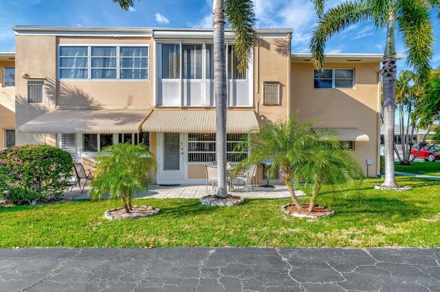 view of front of property with a front yard and stucco siding