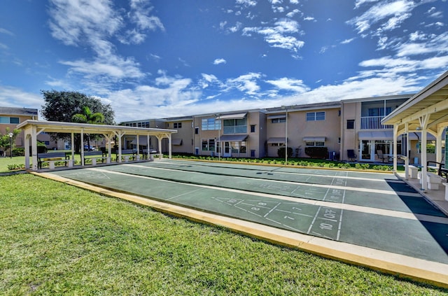 view of community with shuffleboard, a lawn, and a residential view