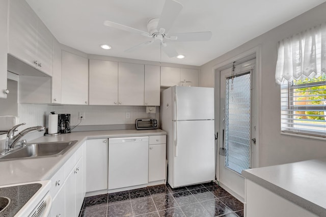 kitchen with light countertops, white appliances, a sink, and decorative backsplash