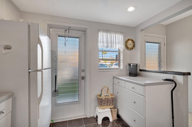 doorway featuring dark tile patterned flooring and recessed lighting