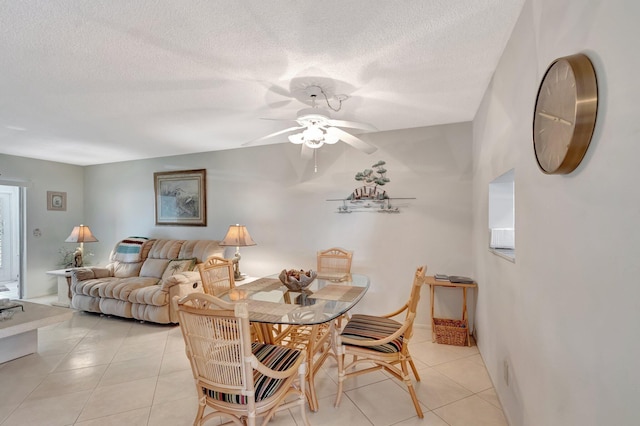 dining space with light tile patterned floors, ceiling fan, and a textured ceiling