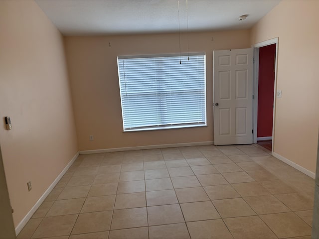 unfurnished room with baseboards and light tile patterned flooring