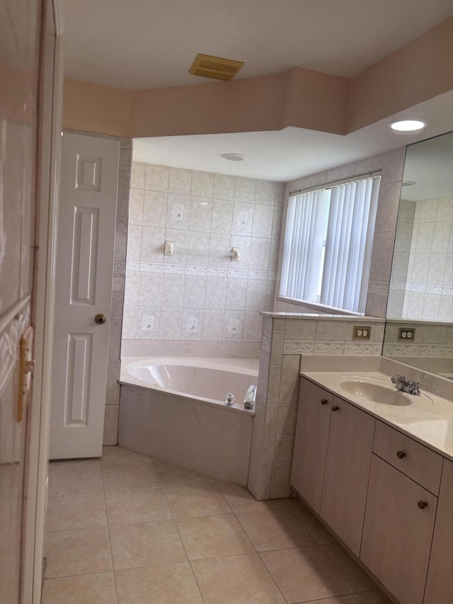 full bath featuring a bath, vanity, tile patterned flooring, and tile walls