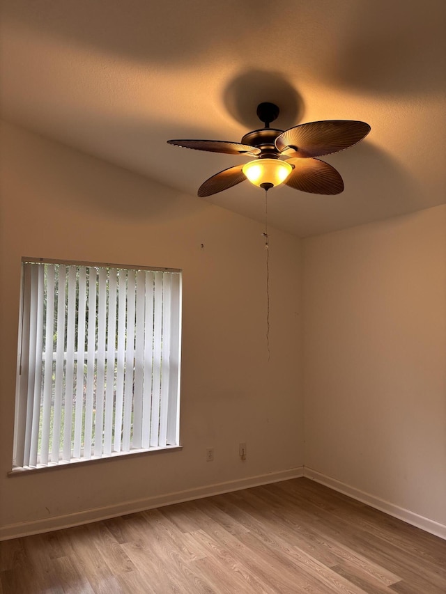 unfurnished room with a ceiling fan, baseboards, and wood finished floors