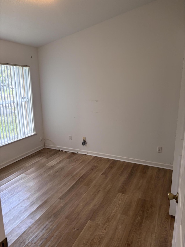 empty room featuring dark wood-style flooring and baseboards