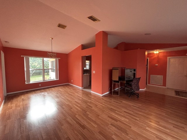 unfurnished living room with vaulted ceiling, wood finished floors, visible vents, and baseboards