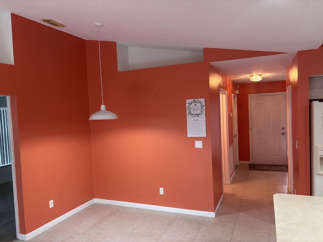 hall featuring light tile patterned floors, visible vents, and baseboards