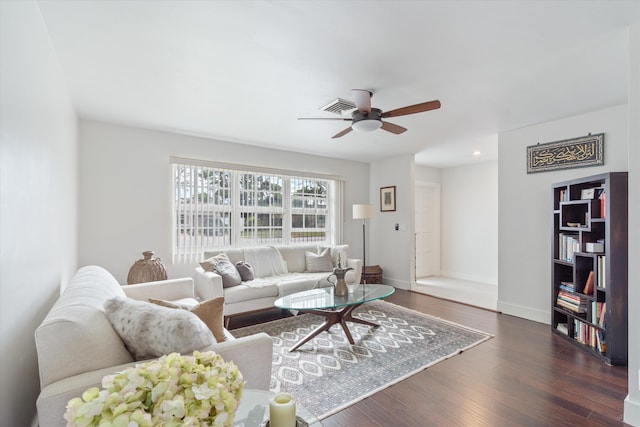 living area featuring visible vents, dark wood finished floors, baseboards, and ceiling fan