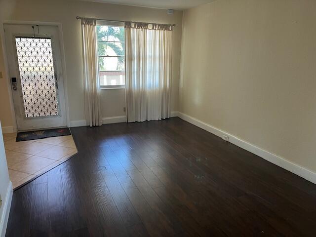 entryway with dark wood finished floors and baseboards