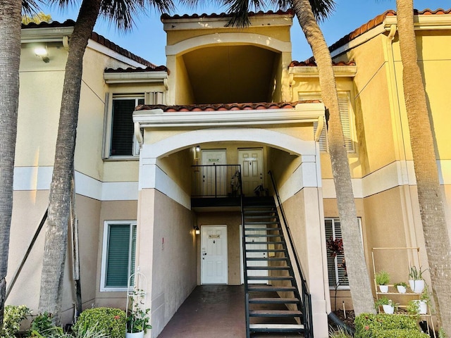 property entrance featuring a tiled roof and stucco siding