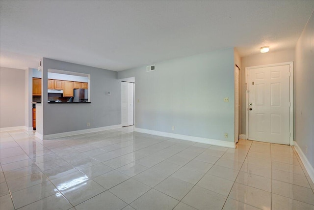 unfurnished living room with light tile patterned floors, baseboards, and visible vents