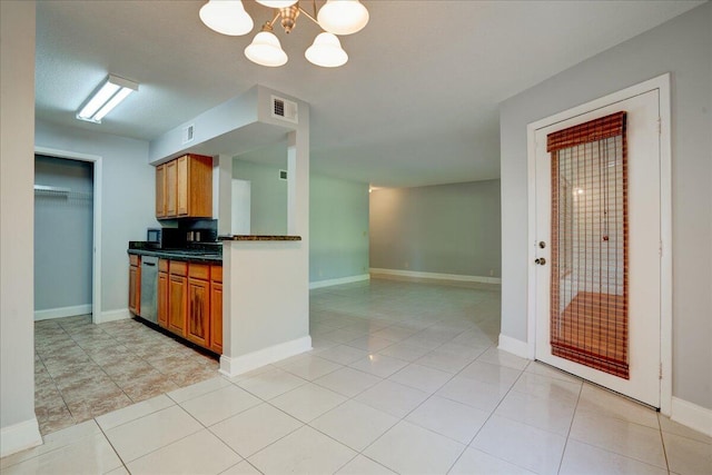 kitchen featuring dishwasher, dark countertops, visible vents, and brown cabinets