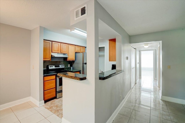 kitchen with dark countertops, under cabinet range hood, visible vents, and appliances with stainless steel finishes