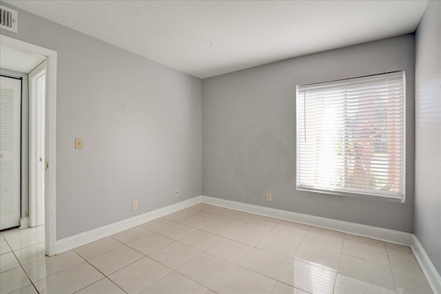 unfurnished room with visible vents, baseboards, and light tile patterned floors