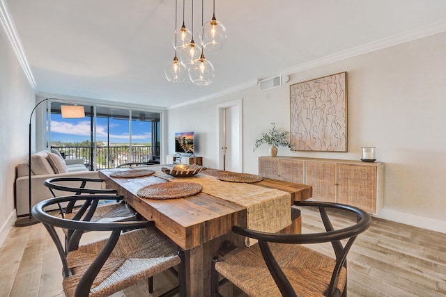 dining room with expansive windows, baseboards, crown molding, and light wood finished floors