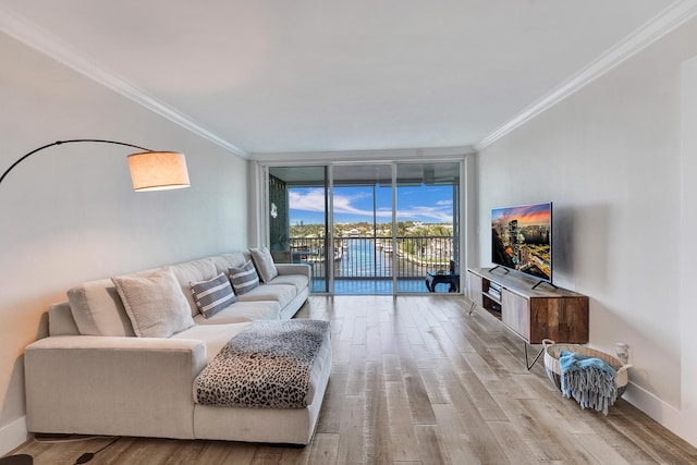 living room featuring light wood finished floors, baseboards, floor to ceiling windows, and ornamental molding