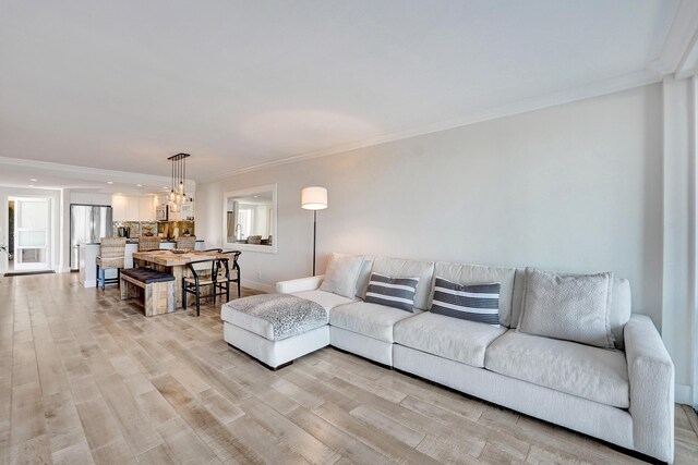 living room with a wall of windows, crown molding, and wood finished floors