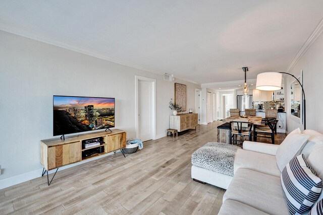 living area with light wood-style floors, crown molding, and baseboards