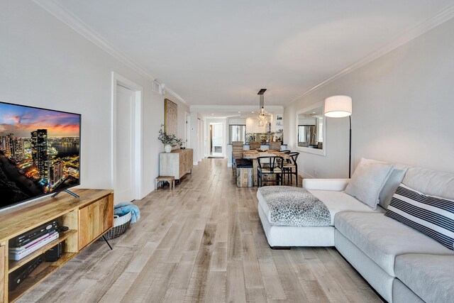 living room with a wall of windows, crown molding, and wood finished floors