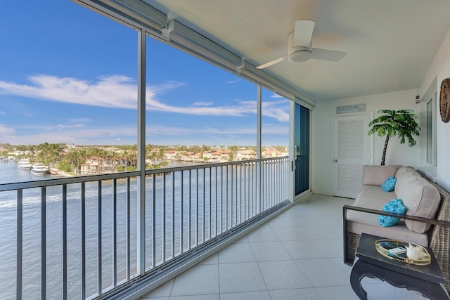 unfurnished sunroom with a water view and a ceiling fan