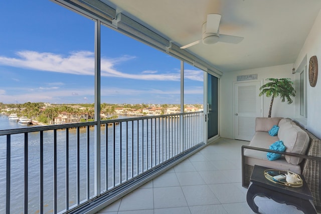 unfurnished sunroom featuring a water view and a ceiling fan