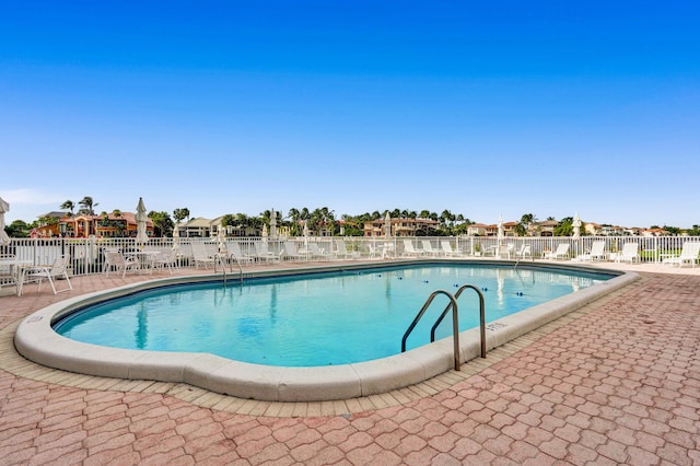 community pool featuring fence and a patio