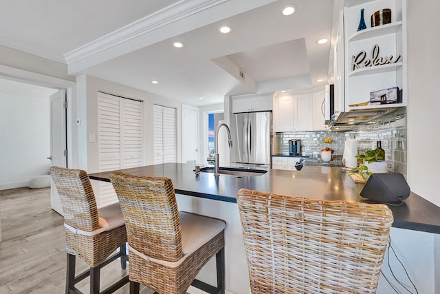 kitchen featuring open shelves, dark countertops, a peninsula, and freestanding refrigerator