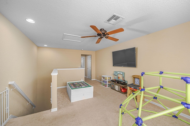 game room featuring visible vents, a textured ceiling, carpet, and baseboards