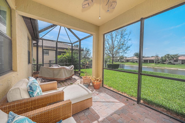 sunroom / solarium featuring a water view, ceiling fan, outdoor lounge area, and a residential view
