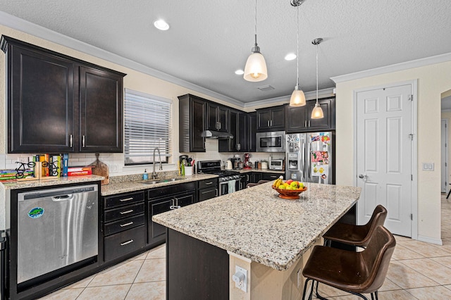 kitchen with crown molding, light tile patterned flooring, appliances with stainless steel finishes, a sink, and a kitchen island