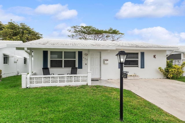 view of front of home with covered porch, a front lawn, and stucco siding