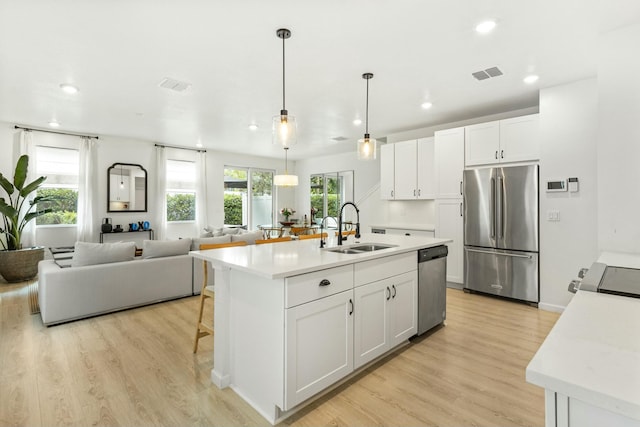 kitchen featuring a sink, stainless steel appliances, visible vents, and light countertops